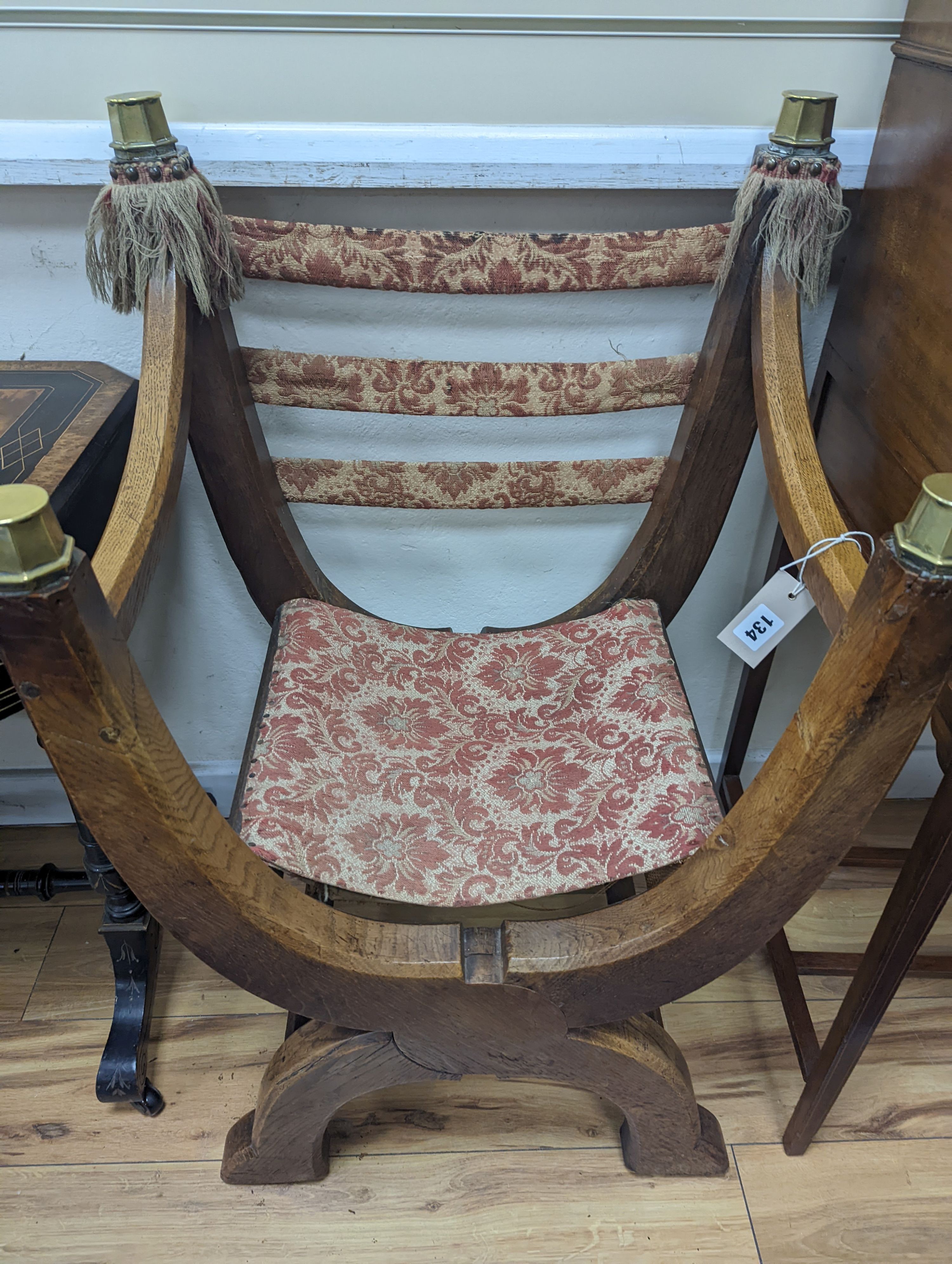 A brass mounted oak folding X framed elbow chair, width 58cm, depth 47cm, height 90cm